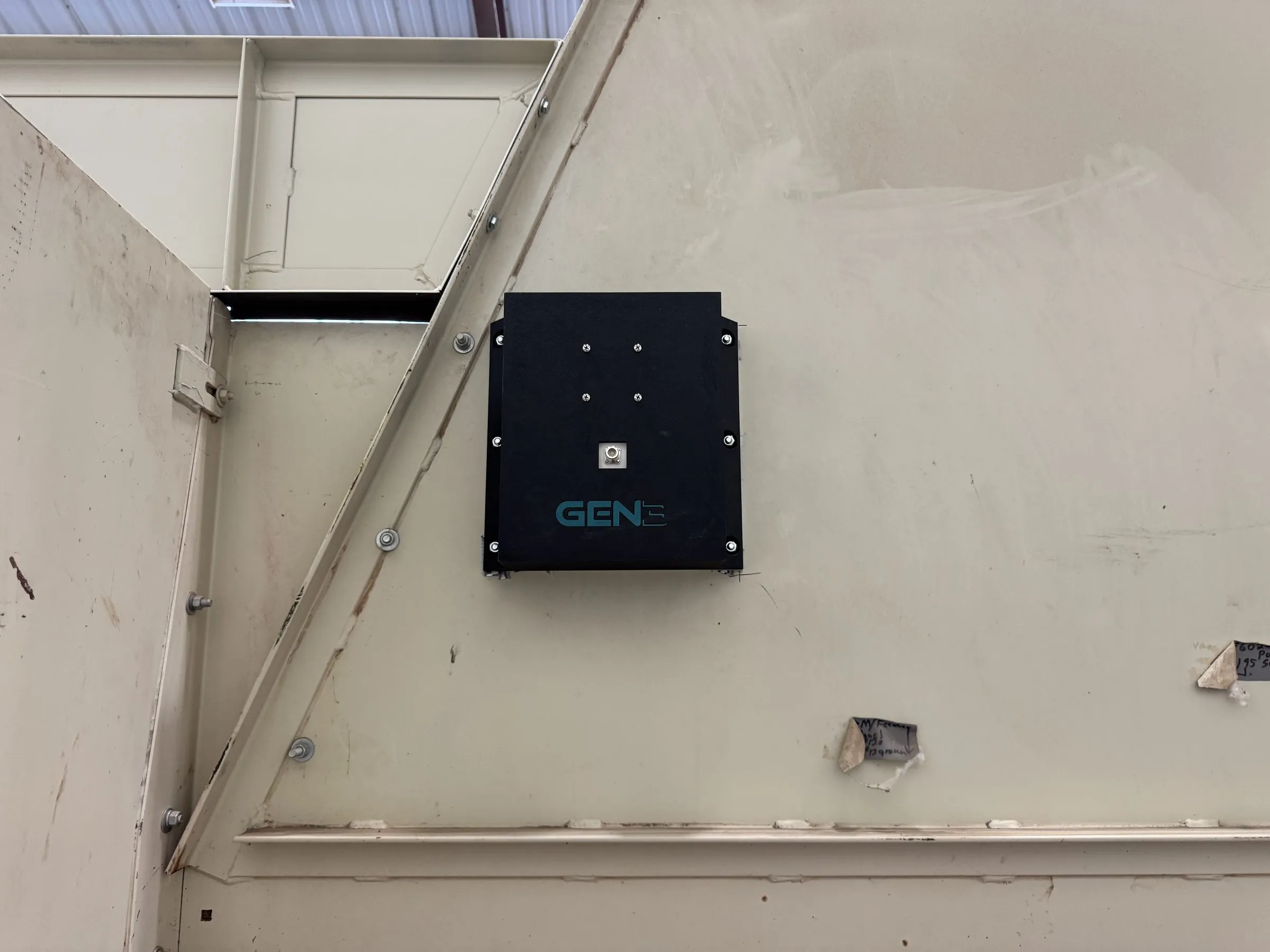 A dark Gen 3 Dynamics antenna plate bolted to the sloped wall of a module feeder