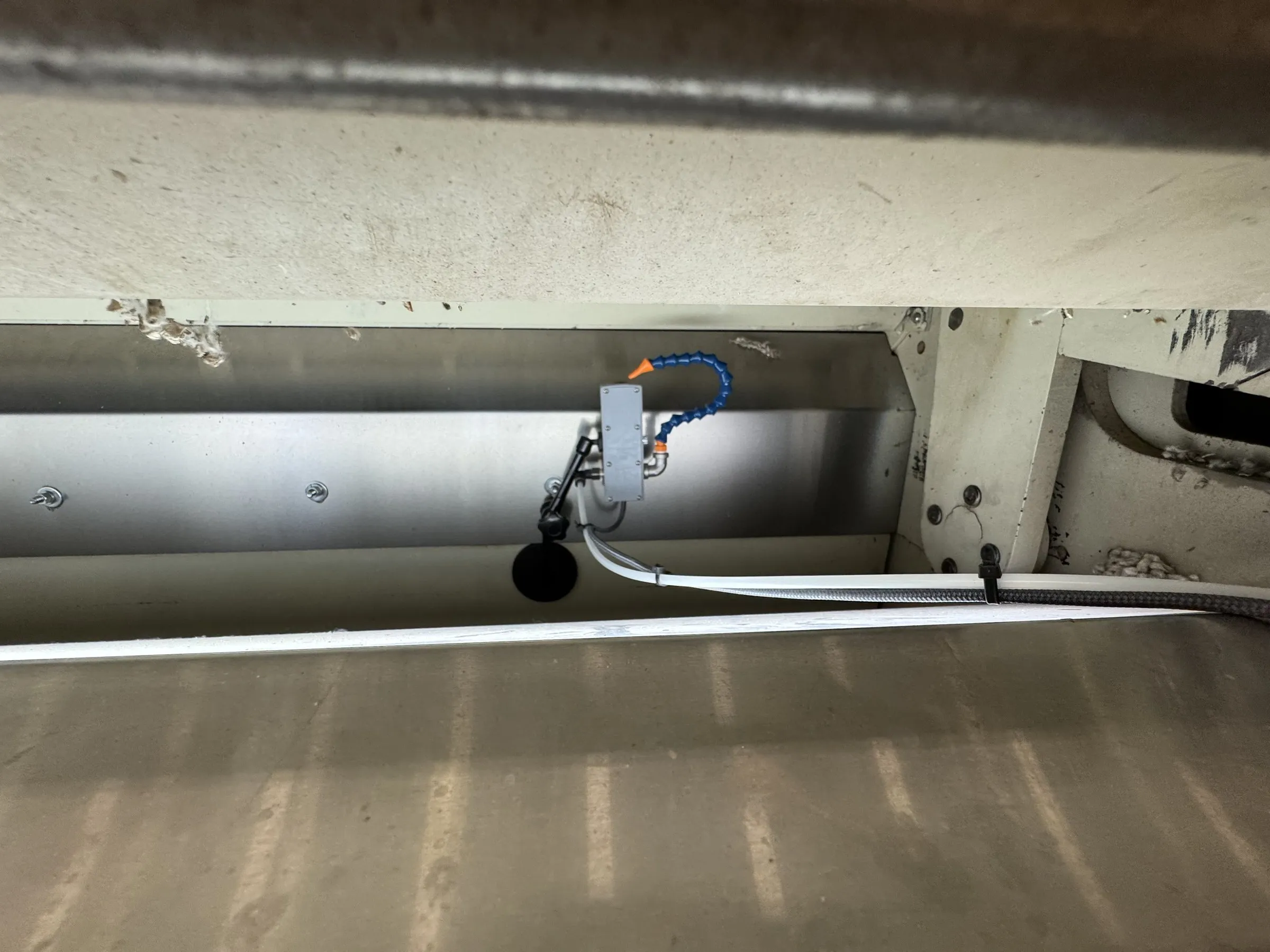 Close view of a TS-1 thermal camera and its adjustable mounting arm inside a gin stand housing
