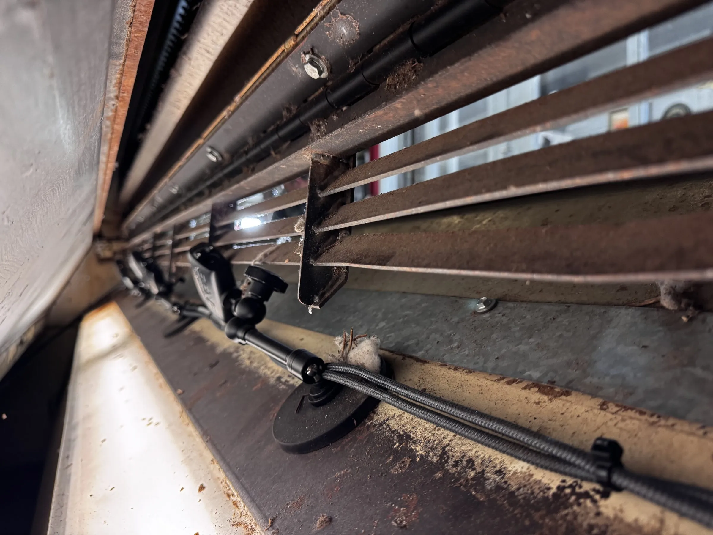 A row of TS-1 thermal cameras on articulated arms mounted inside a gin stand, with lint caught on the frame around them